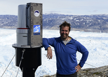 Gordon Hamilton with an automated laser scanning system installed to monitor Helheim Glacier, in Southeast Greenland