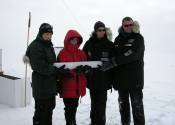 People holding an ice core at Summit, Greenland
