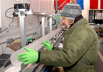 Science technician Tommy Cox measures a section of the WAIS Divide ice core as it begins its journey down the core processing line at the National Ice Core Laboratory near Denver