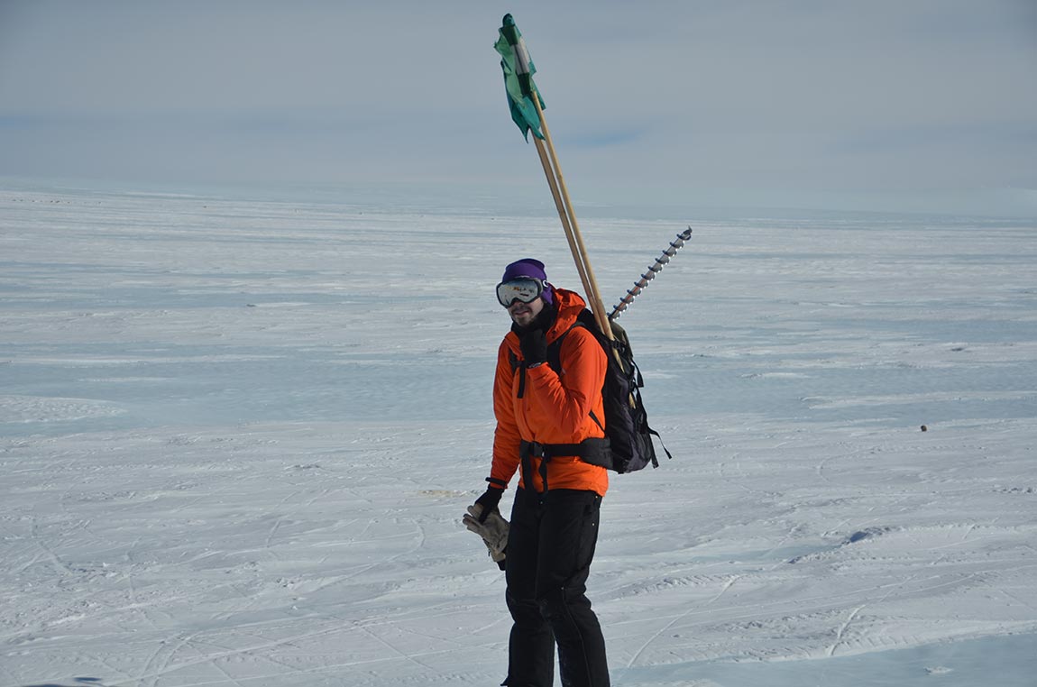 Preston Kemeny (pictured), a research specialist in the Department of Geosciences who was in Antarctica for the first time, carries an ice auger and marker flags