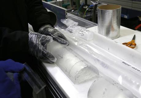 In this Aug. 8, 2016 photo, Geoffrey Hargreaves, curator of the National Ice Core Laboratory, gently places an arctic ice core on a table inside the deep freeze work area at the lab, in Lakewood, Colo