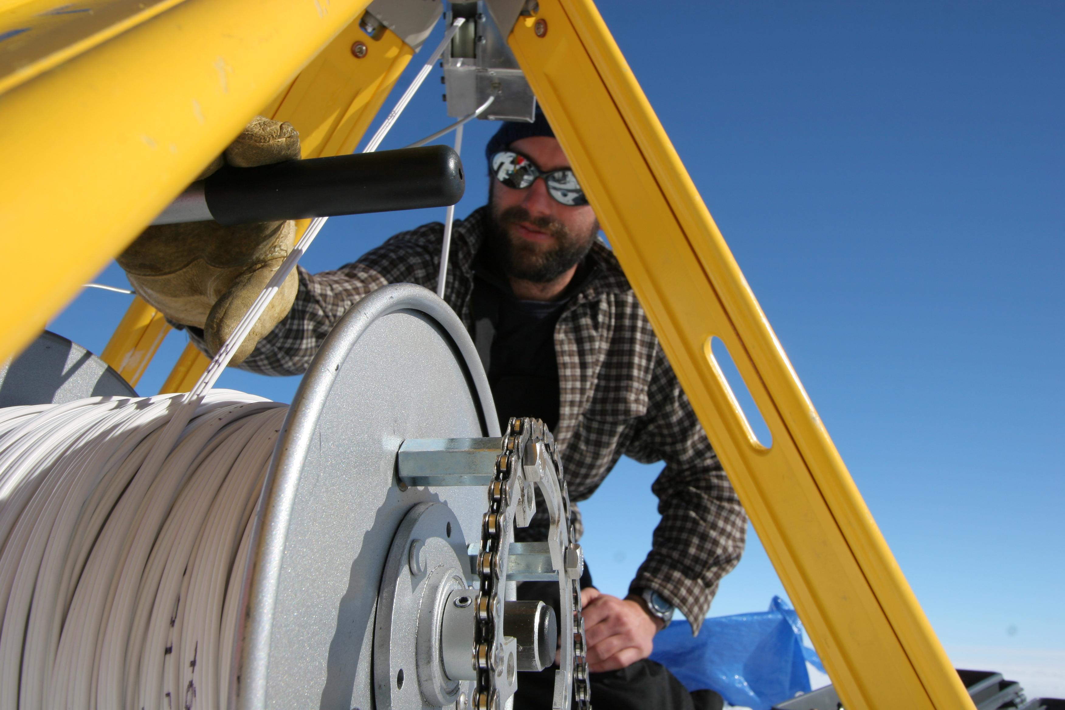 Ben Smith (U. Washington) lowers a video camera into a borehole at the WAIS Divide field camp in West Antarctica