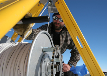 Ben Smith lowers a video camera into a borehole at the WAIS Divide field camp in West Antarctica